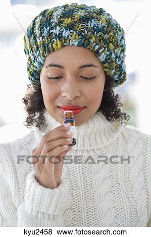 Woman smelling a bottle View Large Photo Image Stock Photo - Woman smelling a bottle. Fotosearch