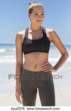 Stock Photograph - Woman standing on the beach. Fotosearch