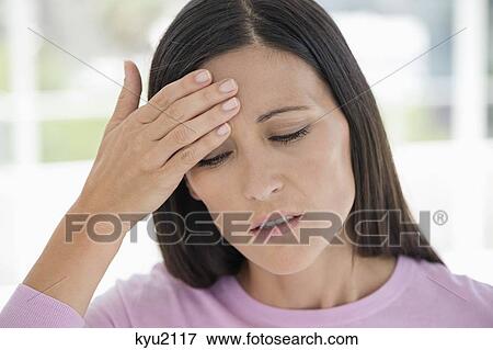 Woman suffering from a headache View Large Photo Image Stock Photo - Woman suffering from a headache. Fotosearch