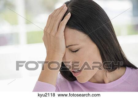 Woman suffering from a headache View Large Photo Image Stock Photo - Woman suffering from a headache. Fotosearch