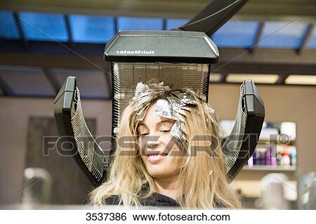 Woman under a heating apparatus for hair View Large Photo Image Stock Photograph - Woman under a heating apparatus for hair. Fotosearch