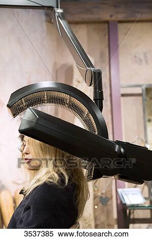 Stock Photography - Woman under a heating apparatus for hair. Fotosearch