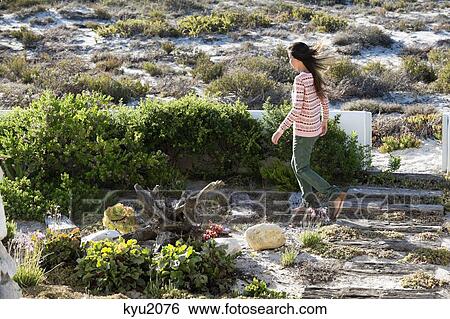 Stock Photograph - Woman walking in vegetation. Fotosearch