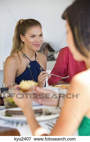 Stock Photo - Woman with her friends at a dining table. Fotosearch