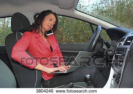 Woman working in her car View Large Photo Image Stock Photograph - Woman working in her car. Fotosearch