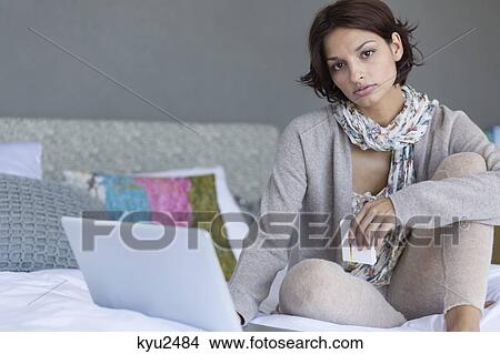 Picture - Woman working on a laptop and looking upset. Fotosearch