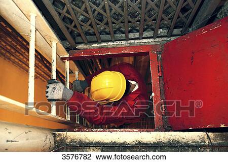 Workman climbing down a ladder. View Large Photo Image Stock Image - Workman climbing down a ladder.. Fotosearch