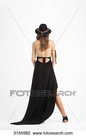 Stock Image - Young back of girl with a hat, wearing a black dress Sanhadja. Fotosearch