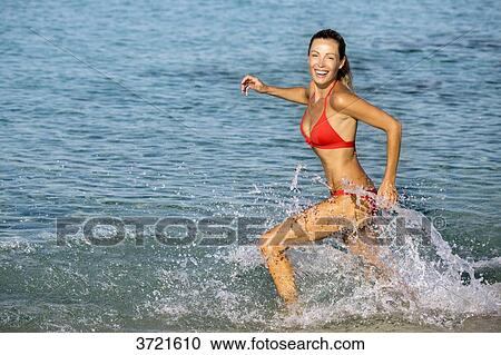 Young blond smilling woman running on the water View Large Photo Image Stock Image - Young blond smilling woman running on the water. Fotosearch