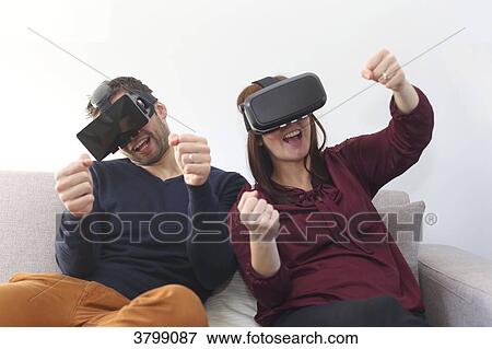Stock Photo - Young couple at home using virtual mask. Fotosearch