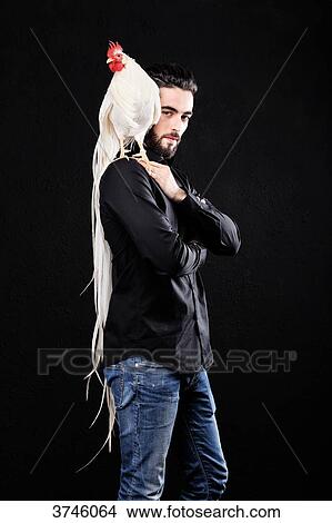 Picture - Young farmer carrying his cock Onagadori Hakuro over the shoulder. Fotosearch