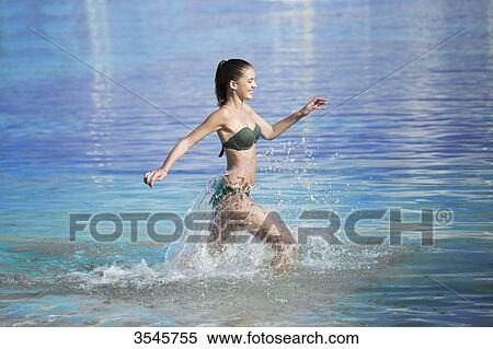 Stock Photography - Young girl running in the sea. Fotosearch