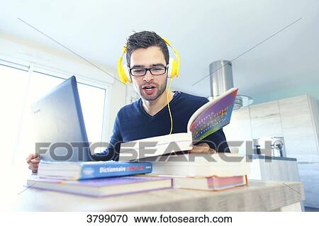 Young man at home learning new language with computer. View Large Photo Image Stock Image - Young man at home learning new language with computer.. Fotosearch