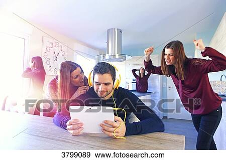 Young man at home playing with computer. His woman do not like that. View Large Photo Image Stock Photo - Young man at home playing with computer. His woman do not like that.. Fotosearch