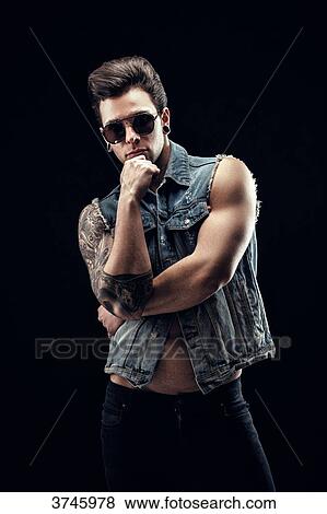 Young man in jeans jacket, short sleeve, hand under chin View Large Photo Image Stock Photo - Young man in jeans jacket, short sleeve, hand under chin. Fotosearch