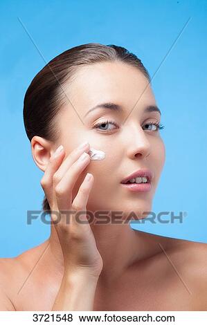 Young woman apply moisturizer on her face View Large Photo Image Stock Photo - Young woman apply moisturizer on her face. Fotosearch