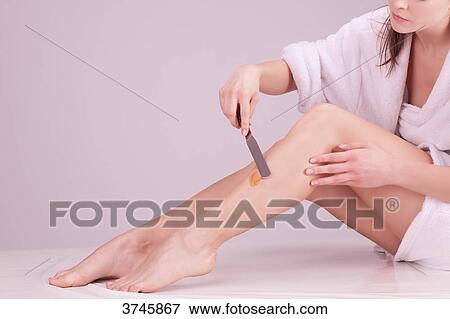 Young woman applying wax on her legs View Large Photo Image Stock Photo - Young woman applying wax on her legs. Fotosearch