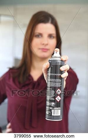 Stock Photography - Young woman at home using air spray. Fotosearch