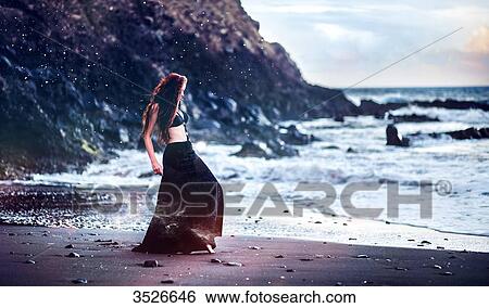 Young woman, dancing on a black sand beach View Large Photo Image Stock Photograph - Young woman, dancing on a black sand beach. Fotosearch