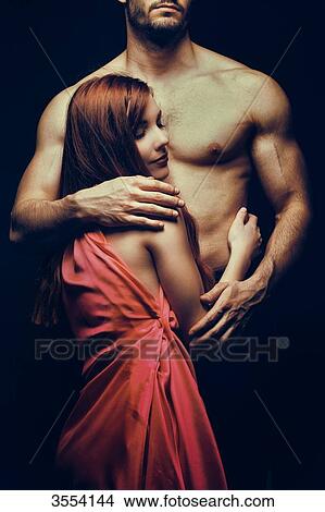 Picture - Young woman embraced by a man. Fotosearch