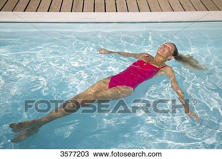 Young woman floating in a pool View Large Photo Image Stock Image - Young woman floating in a pool. Fotosearch