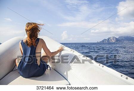 Young woman from behind, contemplates the island of Capri, in front of a boat View Large Photo Image Picture - Young woman from behind, contemplates the island of Capri, in front of a boat. Fotosearch