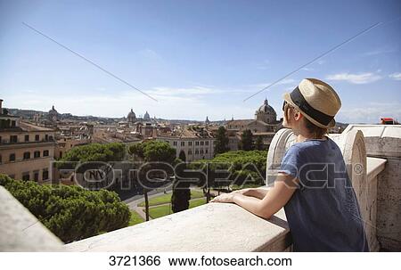 Young woman from behind, leaning on a low wall, and the city of Rome View Large Photo Image Stock Photograph - Young woman from behind, leaning on a low wall, and the city of Rome. Fotosearch