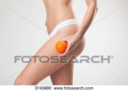 Young woman holding an orange on the top of his thigh View Large Photo Image Stock Image - Young woman holding an orange on the top of his thigh. Fotosearch