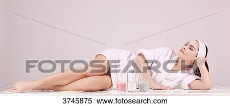Young woman in a bathrobe, lying, looking up View Large Photo Image Stock Photography - Young woman in a bathrobe, lying, looking up. Fotosearch