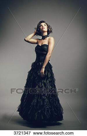 Young woman in evening dress looking up, hands behind head View Large Photo Image Stock Photo - Young woman in evening dress looking up, hands behind head. Fotosearch