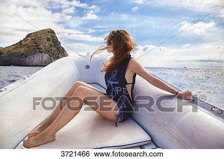 Young woman in profile, contemplates the island of Capri, in front of a boat View Large Photo Image Stock Photograph - Young woman in profile, contemplates the island of Capri, in front of a boat. Fotosearch