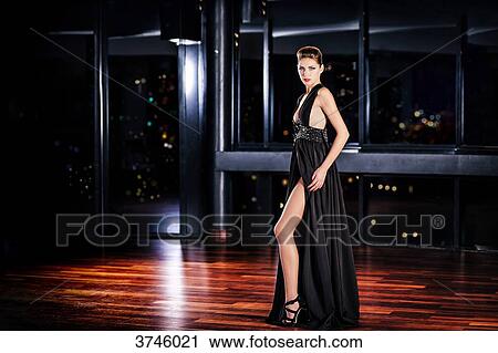 Young woman in profile evening dress standing, looking toward the lens View Large Photo Image Stock Image - Young woman in profile evening dress standing, looking toward the lens. Fotosearch