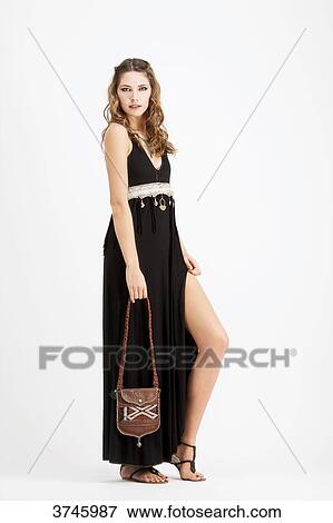 Young woman in profile, wearing a handbag and a black dress Sanhadja View Large Photo Image Stock Photo - Young woman in profile, wearing a handbag and a black dress Sanhadja. Fotosearch