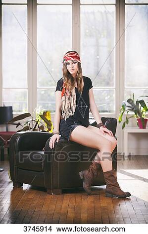 Young woman in shorts, t-shirt and headband Sanhadja sitting on a leather chair View Large Photo Image Picture - Young woman in shorts, t-shirt and headband Sanhadja sitting on a leather chair. Fotosearch