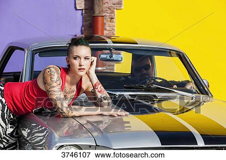 Young woman leaning on a 1966 Ford Mustang volan a man in the twilight View Large Photo Image Stock Photo - Young woman leaning on a 1966 Ford Mustang volan a man in the twilight. Fotosearch