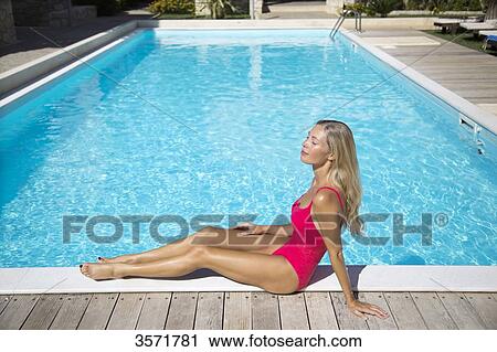 Stock Image - Young woman on the edge of a pool. Fotosearch