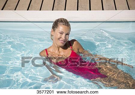 Young woman posing in a swimming pool View Large Photo Image Stock Image - Young woman posing in a swimming pool. Fotosearch