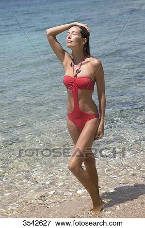 Young woman posing in the sun in swimsuit View Large Photo Image Stock Photo - Young woman posing in the sun in swimsuit. Fotosearch
