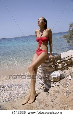 Young woman posing in the sun in swimsuit View Large Photo Image Stock Photograph - Young woman posing in the sun in swimsuit. Fotosearch