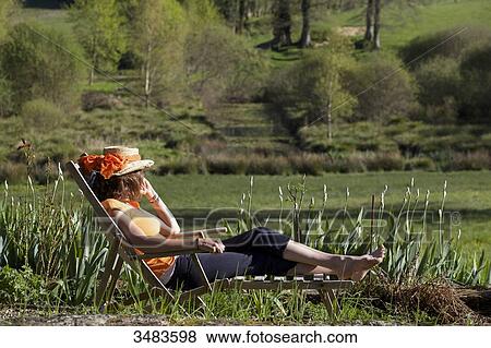 Young woman resting in deckchair View Large Photo Image Stock Photo - Young woman resting in deckchair. Fotosearch
