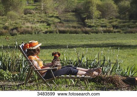 Young woman resting in deckchair View Large Photo Image Stock Photo - Young woman resting in deckchair. Fotosearch