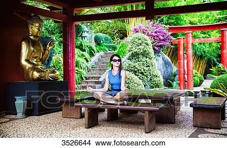 Young woman sitting cross-legged, meditating View Large Photo Image Picture - Young woman sitting cross-legged, meditating. Fotosearch