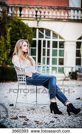 Young woman sitting on an iron chair View Large Photo Image Stock Image - Young woman sitting on an iron chair. Fotosearch