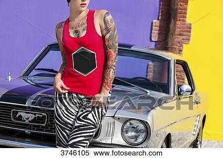 Young woman sitting on the hood of a Ford Mustang View Large Photo Image Stock Photography - Young woman sitting on the hood of a Ford Mustang. Fotosearch
