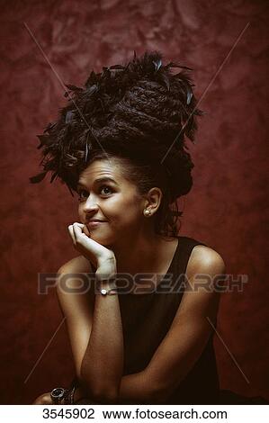 Young woman sitting with a hat made of hair and feathers View Large Photo Image Stock Image - Young woman sitting with a hat made of hair and feathers. Fotosearch