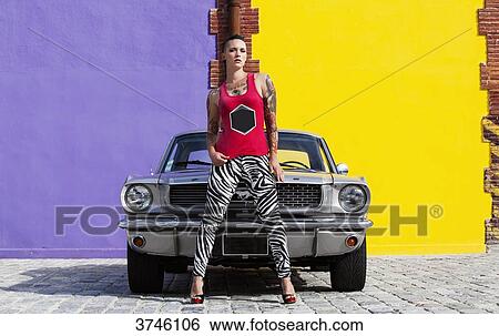 Young woman standing in front of a Ford Mustang View Large Photo Image Stock Photograph - Young woman standing in front of a Ford Mustang. Fotosearch