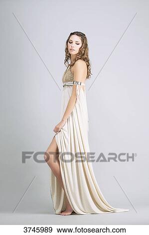 Young woman standing in profile, wearing a beige dress Sanhadja View Large Photo Image Stock Photo - Young woman standing in profile, wearing a beige dress Sanhadja. Fotosearch