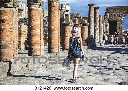 Young woman tourist, from the back, walking in the ruins of Pompeii View Large Photo Image Stock Photograph - Young woman tourist, from the back, walking in the ruins of Pompeii. Fotosearch