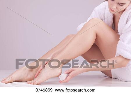Young woman using a pumice stone View Large Photo Image Stock Photo - Young woman using a pumice stone. Fotosearch