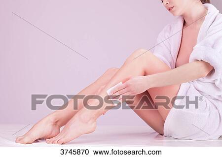 Young woman using a sponge massage on her leg View Large Photo Image Stock Image - Young woman using a sponge massage on her leg. Fotosearch